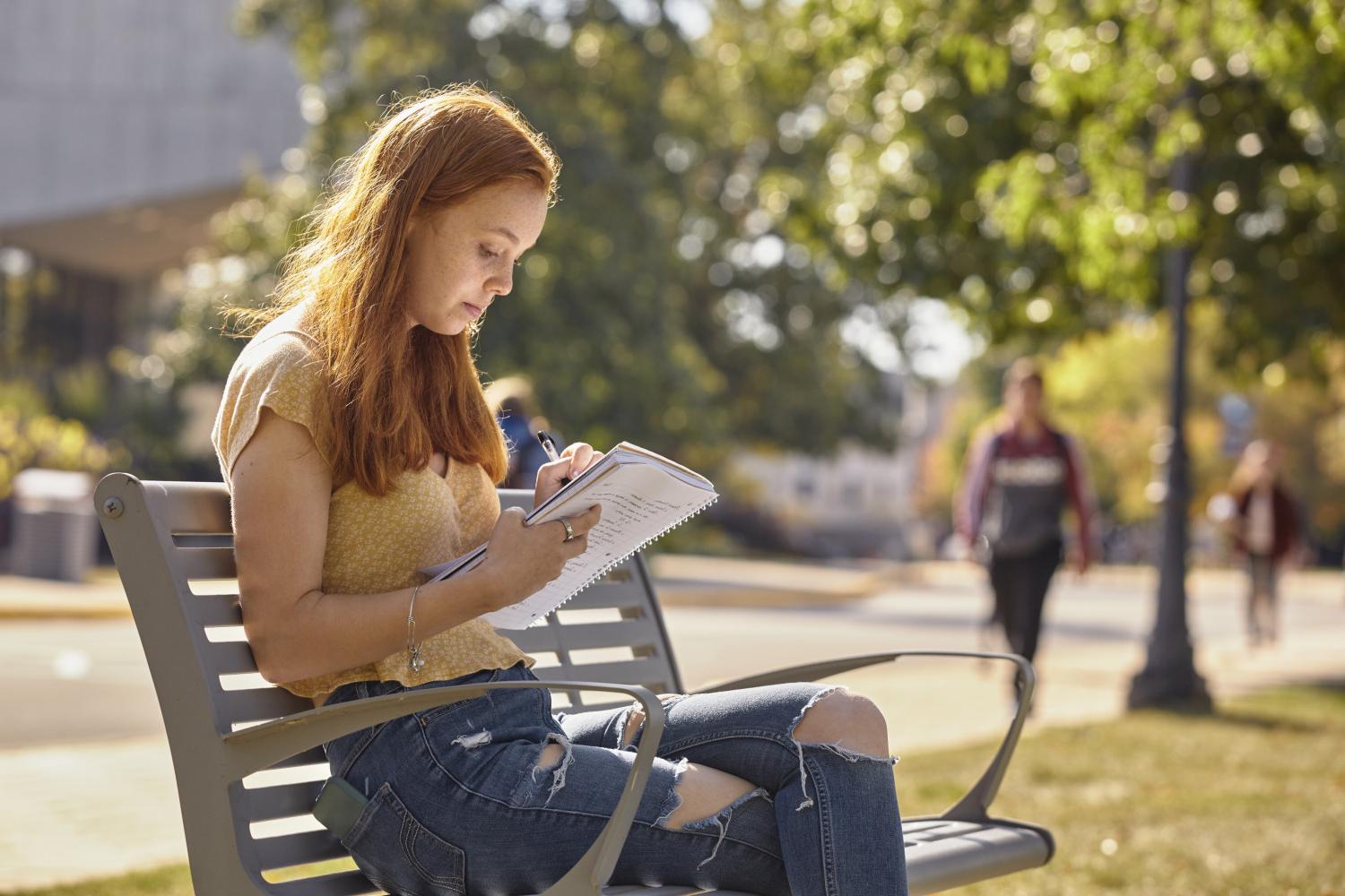 一位<a href='http://oavfr4uz.aurora-ro.com'>全球十大赌钱排行app</a>学院的学生在校园里的长椅上读书.